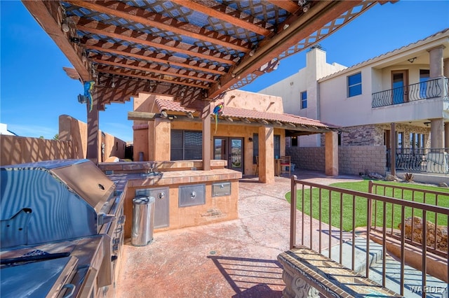 view of patio / terrace with exterior kitchen, fence, and grilling area