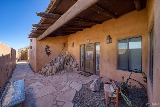 entrance to property with fence and a patio