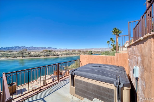 view of patio / terrace with a water and mountain view