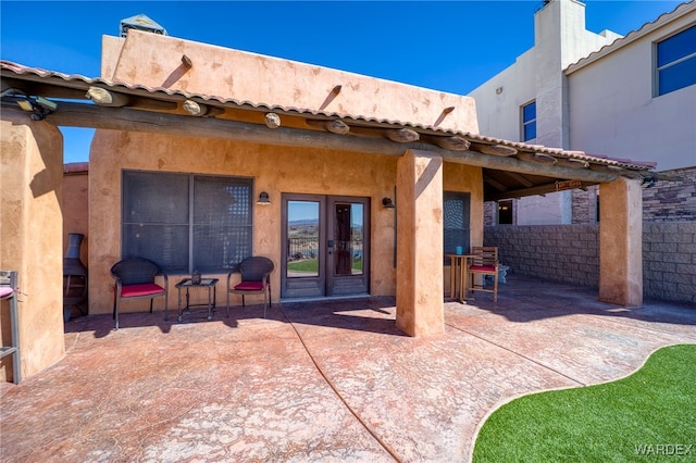 exterior space featuring french doors, a patio area, and fence