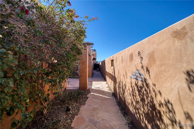 view of property exterior with a patio area and fence