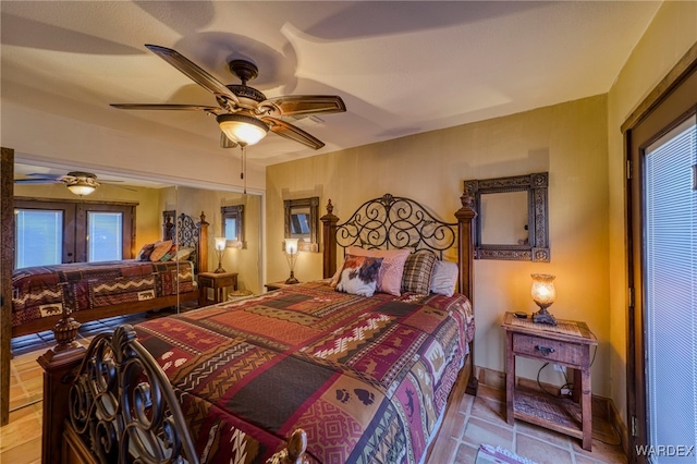 tiled bedroom with ceiling fan and french doors