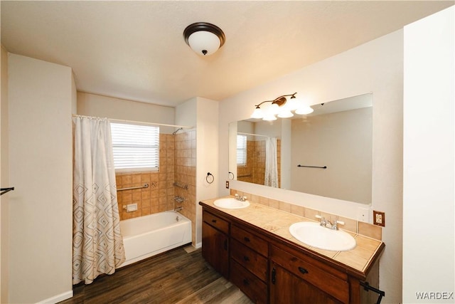 full bath featuring double vanity, shower / bath combination with curtain, wood finished floors, and a sink