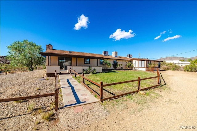 single story home featuring a front lawn and a chimney