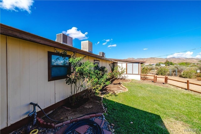 view of yard featuring central AC unit and fence