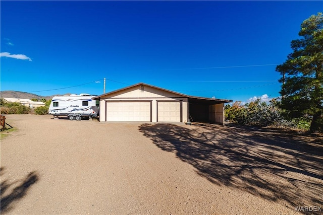 view of front of home featuring a detached garage and an outbuilding