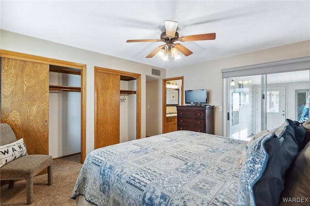 bedroom featuring visible vents, a ceiling fan, carpet, and multiple closets