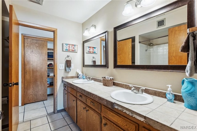 full bath featuring a sink, visible vents, double vanity, and tile patterned floors