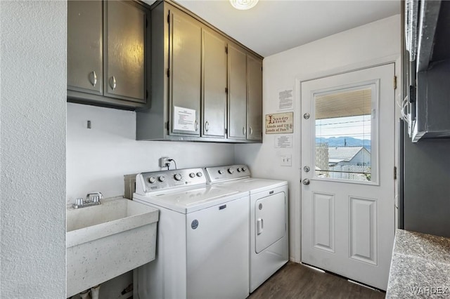 laundry area featuring dark wood finished floors, cabinet space, independent washer and dryer, and a sink