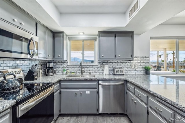 kitchen featuring a sink, visible vents, gray cabinets, and stainless steel appliances