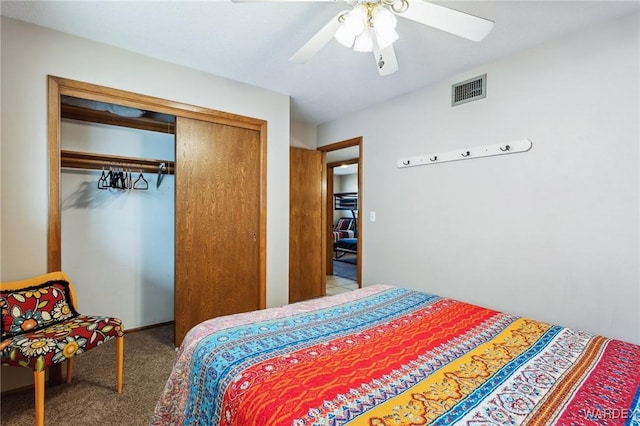 bedroom with a ceiling fan, carpet flooring, visible vents, and a closet