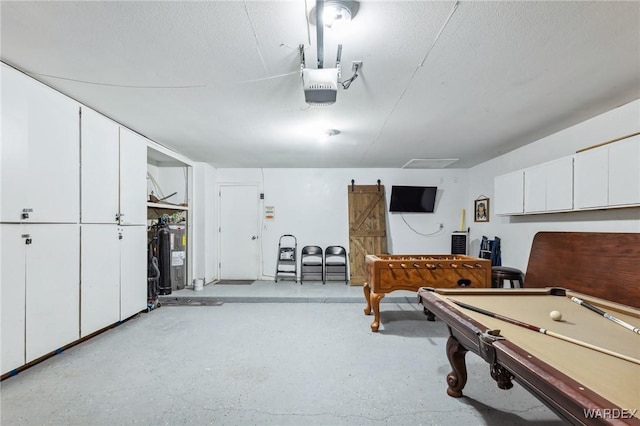 recreation room with pool table, a textured ceiling, and a garage