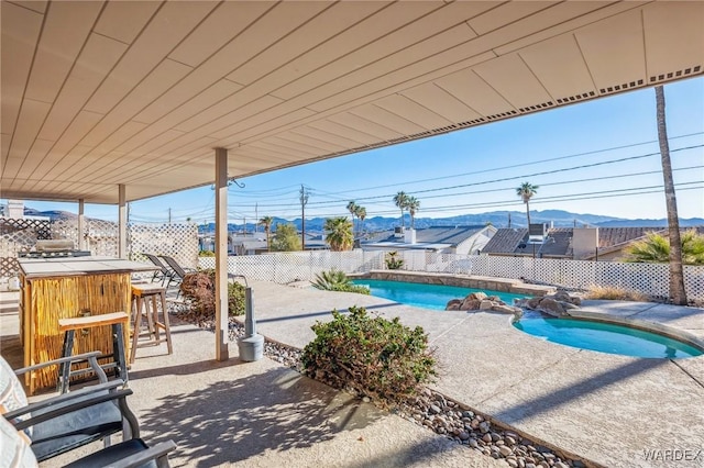 view of pool with a mountain view, a patio area, a fenced in pool, and a fenced backyard