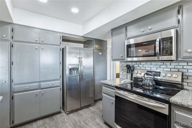 kitchen with decorative backsplash, appliances with stainless steel finishes, and gray cabinetry