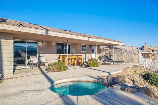 view of pool featuring an in ground hot tub, a patio area, and outdoor dry bar