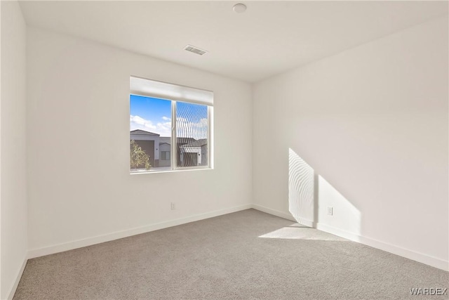 empty room with light carpet, visible vents, and baseboards