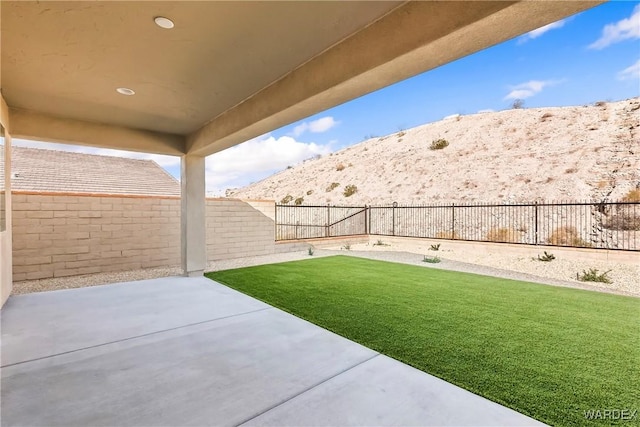 view of yard with a fenced backyard, a patio, and a mountain view