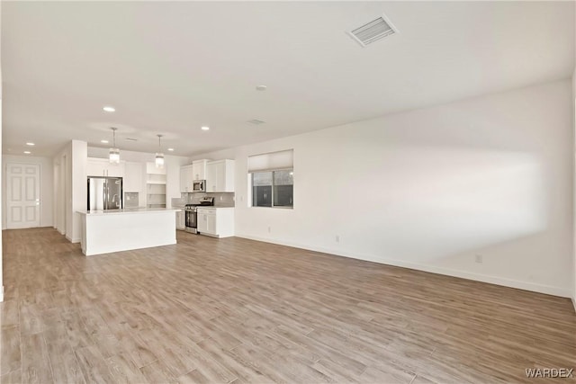 unfurnished living room with light wood-style floors, recessed lighting, visible vents, and baseboards