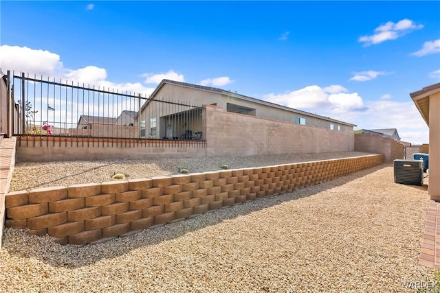 view of side of property featuring cooling unit and a fenced backyard