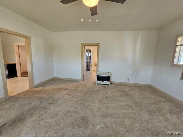 unfurnished room with baseboards, a ceiling fan, light colored carpet, and heating unit