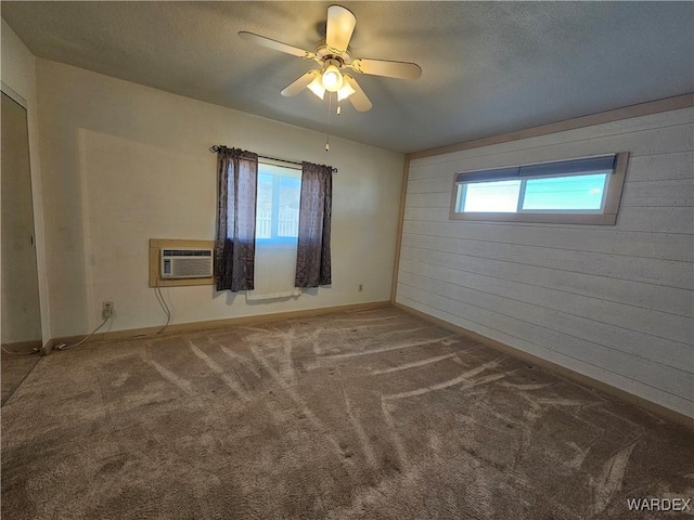 carpeted empty room featuring a textured ceiling, a wall mounted air conditioner, a ceiling fan, and wooden walls