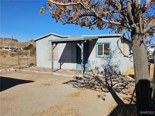 rear view of house with fence and stucco siding