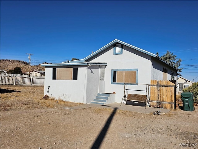 view of front of house featuring fence and stucco siding