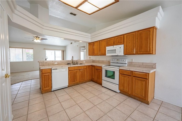 3103 Crater Dr, Lake Havasu, AZ 86404 - kitchen featuring white appliances, a sink, a peninsula, brown cabinetry, and a ceiling fan