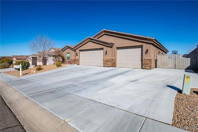 ranch-style house featuring stucco siding, concrete driveway, a gate, a garage, and stone siding