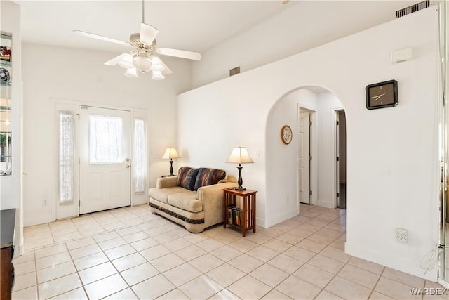 interior space featuring visible vents, arched walkways, a ceiling fan, and light tile patterned flooring