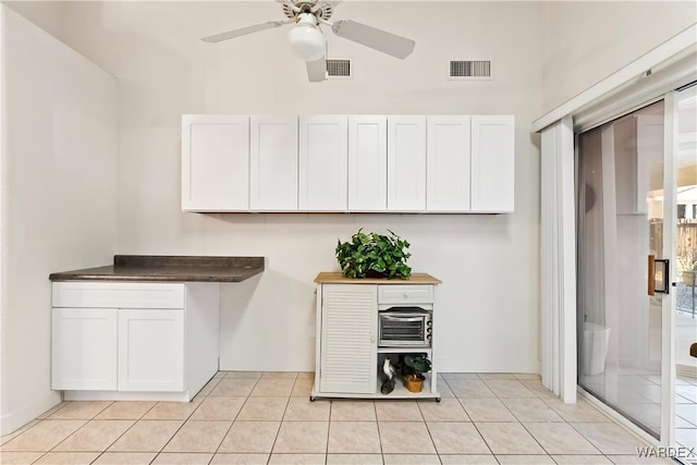 kitchen with light tile patterned floors, visible vents, and white cabinets