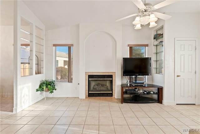 unfurnished living room featuring built in features, a tile fireplace, tile patterned flooring, and baseboards