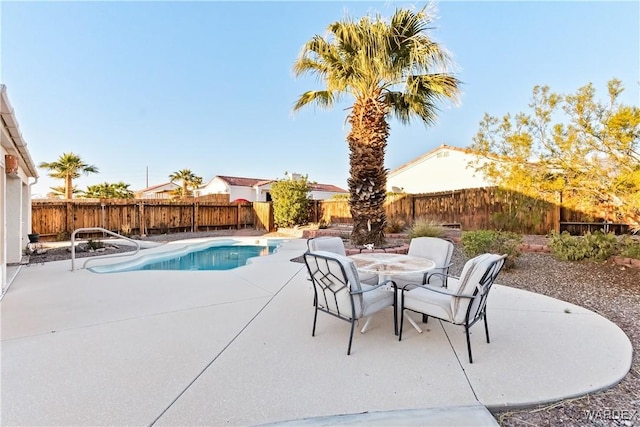 view of pool with outdoor dining space, a patio area, and a fenced backyard