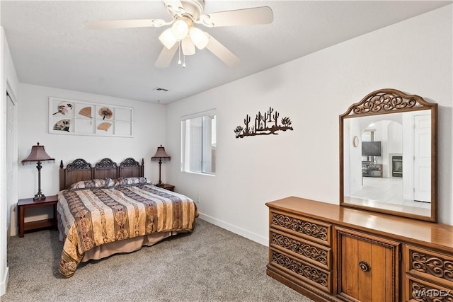 carpeted bedroom with a ceiling fan, visible vents, and baseboards