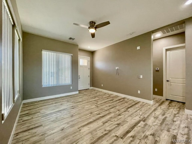 unfurnished room with light wood-style floors, baseboards, and visible vents