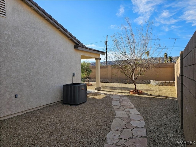 view of yard with a patio, a fenced backyard, and central air condition unit