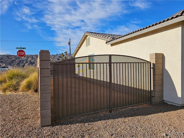 view of gate featuring a mountain view and fence