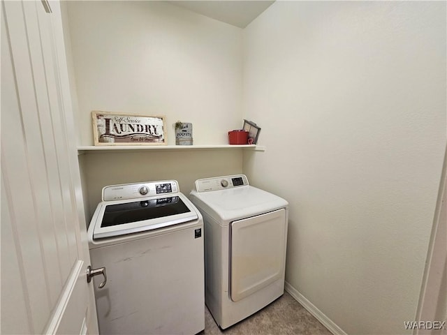 laundry room featuring laundry area, baseboards, and separate washer and dryer