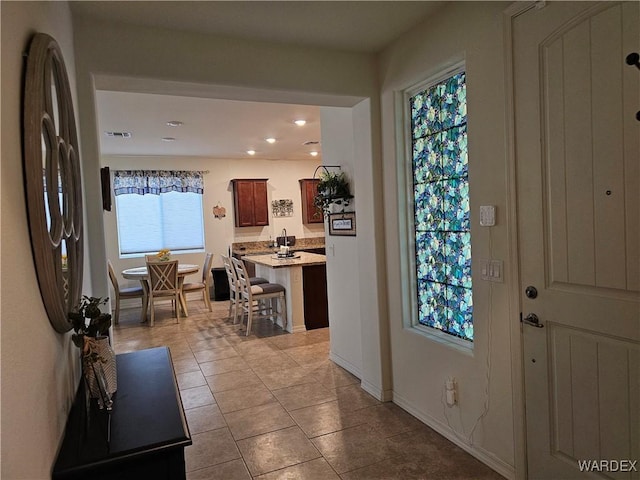 entryway with recessed lighting, baseboards, and light tile patterned floors