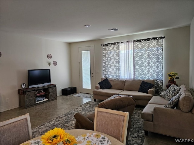 tiled living room featuring plenty of natural light and visible vents