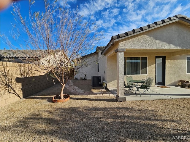 back of house featuring a fenced backyard, central AC, a tile roof, stucco siding, and a patio area