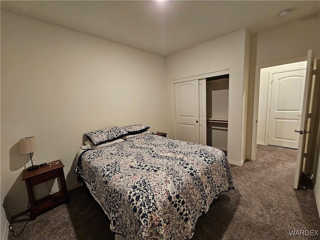 bedroom with a closet, dark carpet, and baseboards