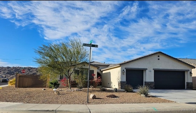 ranch-style house featuring stucco siding, concrete driveway, an attached garage, stone siding, and a tiled roof