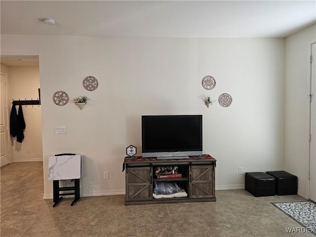 tiled living room featuring baseboards