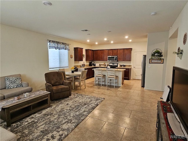 living area featuring baseboards, visible vents, and recessed lighting