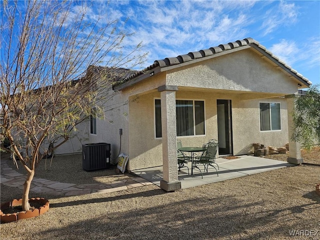 rear view of house with a tile roof, a patio area, stucco siding, and central air condition unit