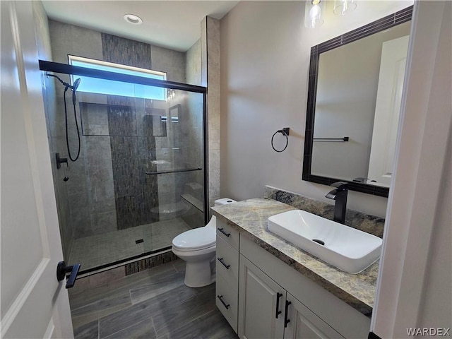 bathroom featuring a stall shower, vanity, and toilet