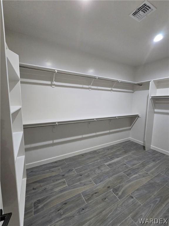 spacious closet featuring dark wood-style flooring and visible vents