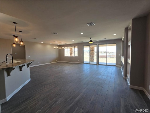 unfurnished living room featuring visible vents, baseboards, dark wood finished floors, and recessed lighting