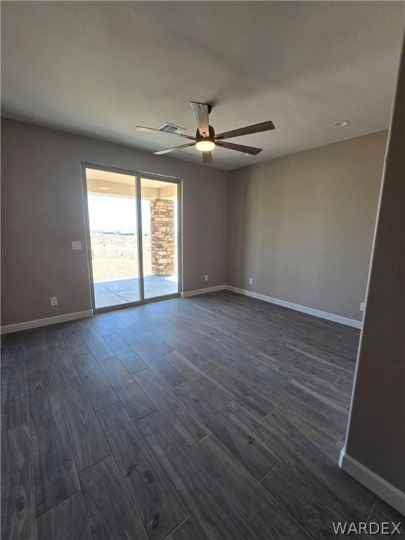 empty room featuring baseboards, dark wood finished floors, and a ceiling fan